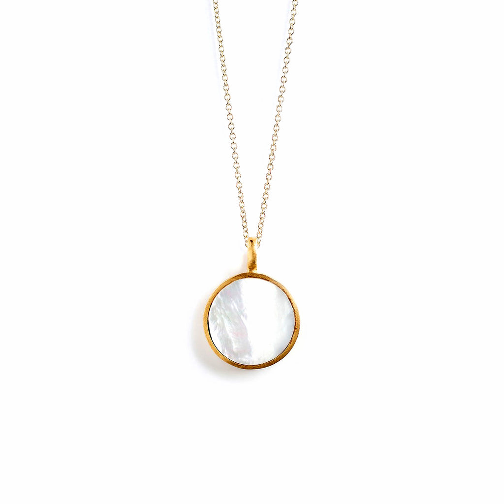 The Bestselling Porthole Necklace with a gemstone slice of Mother of Pearl, framed in a layer of brushed gold. This circular statement pendant is on on a long chain, and can be worn solo or layered with other necklaces.