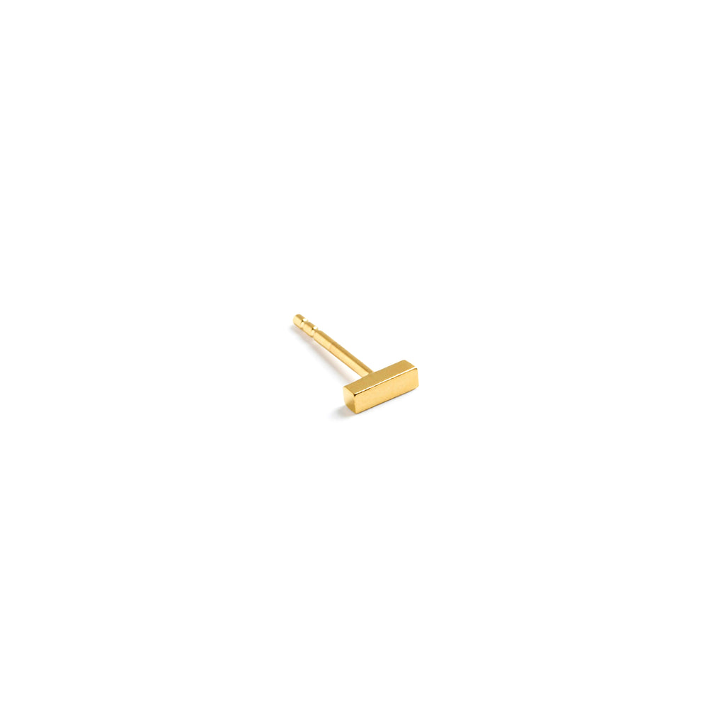 Wanderlust Life Tonina single gold bar ear stud that makes a bold, graphic statement. Available as a pair or singularly to mix and match to create your own ear stack. These minimal studs are proudly designed in Devon and handcrafted by Wanderlust Life global artisan partners.
