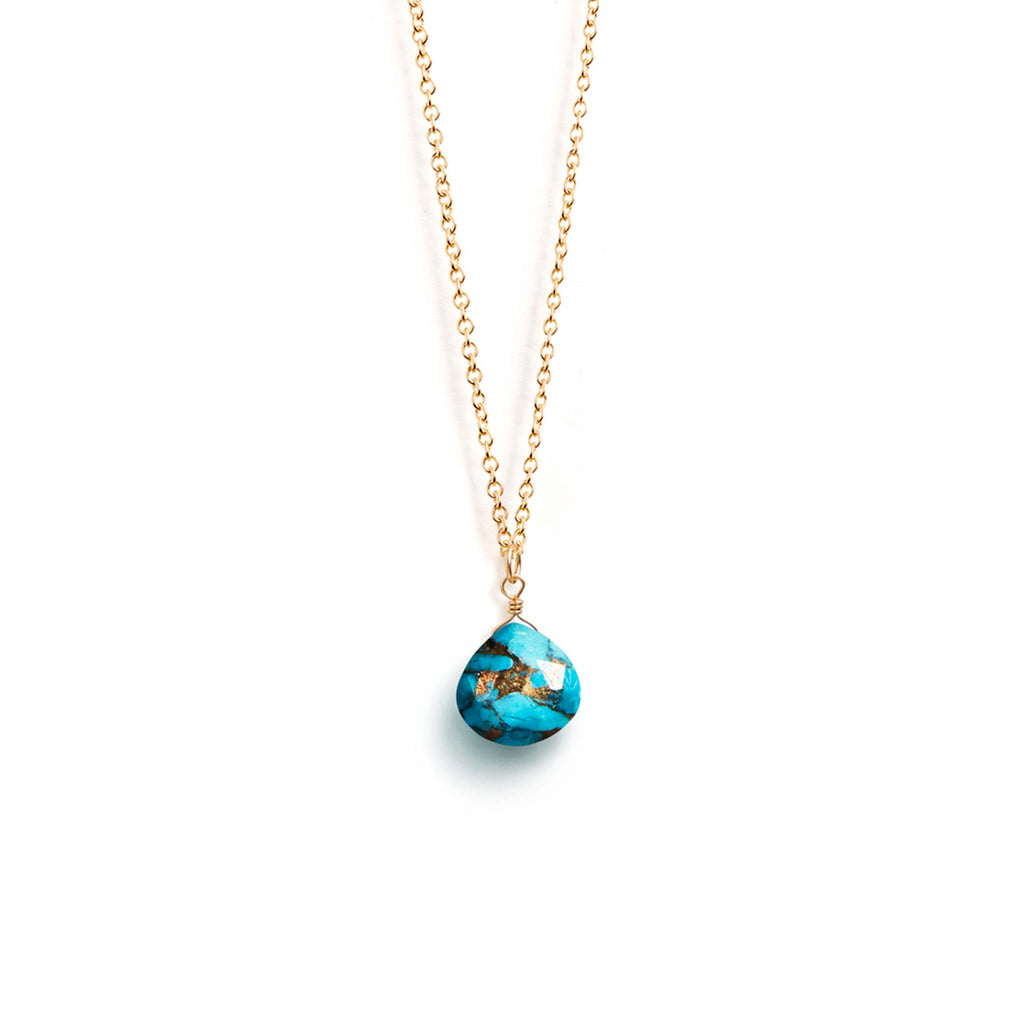  A faceted Mohave Turquoise gemstone features an organic pattern of flecks of gold running throughout its surface. This turquoise gem delicately hands on a minimal 14k gold fill chain.