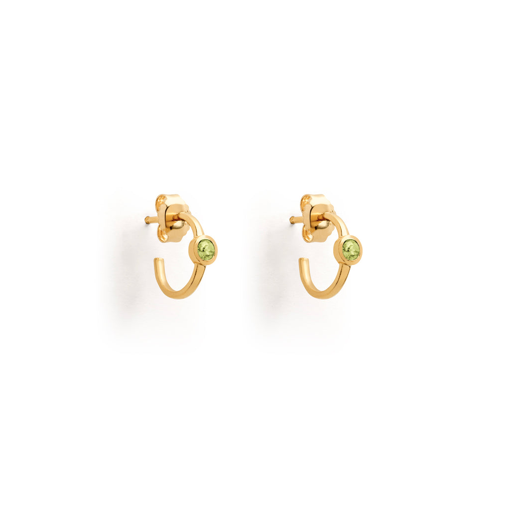 Meaningful birthstone earrings for August feature round peridot gemstones fixed upon the surface of three-quarter hoops. Minimal and meaningful birthstone jewellery, perfect for August birthdays and anniversaries. Designed in Devon and handcrafted by our Wanderlust Life Global Artisan Partners.