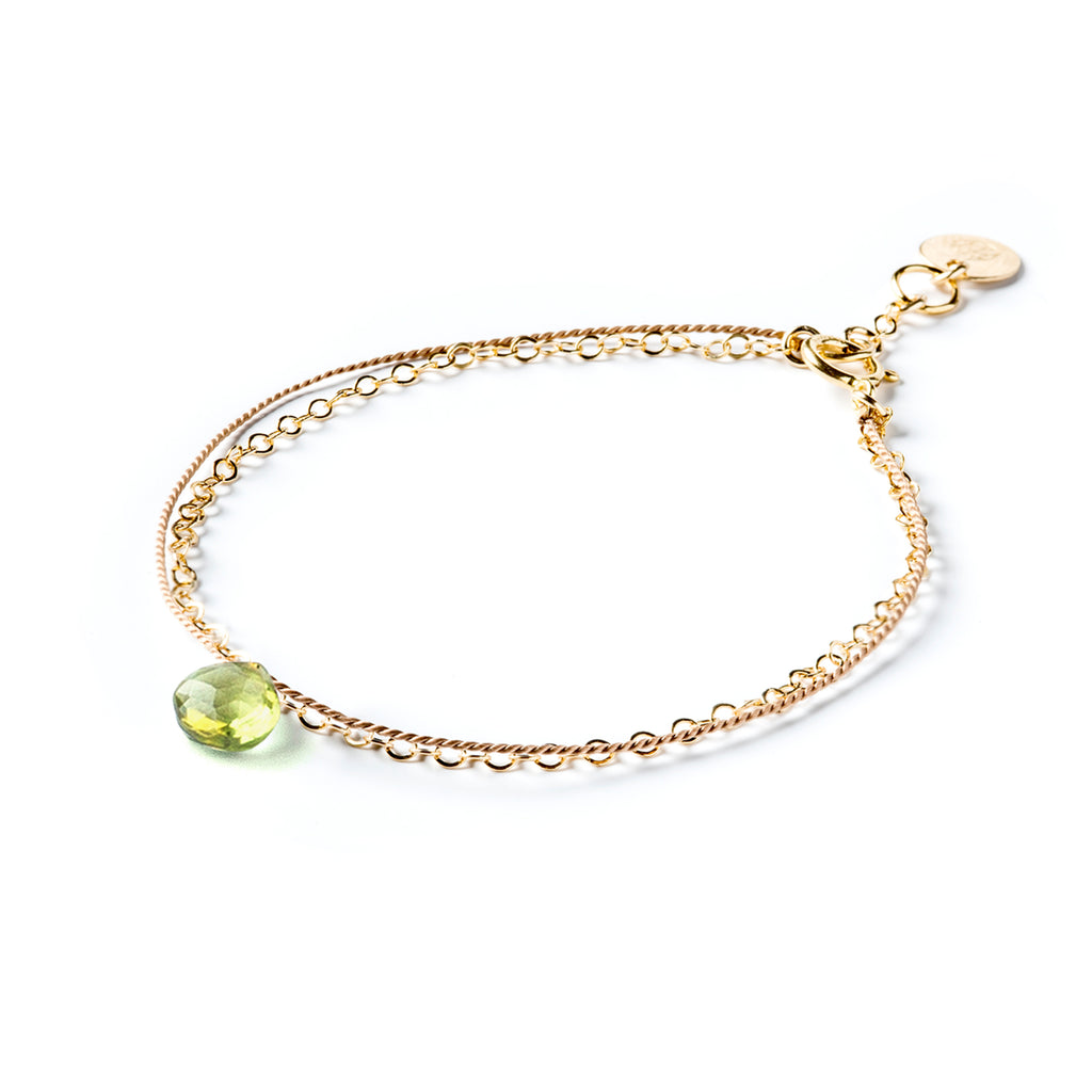 August Birthstone Bracelet with a green peridot gemstone. Creating the appearance of two bracelets layered into a stack, this gemstone bracelet combines a layer of silk and a layer of gold fill chain. Wanderlust Life’s signature aesthetic of minimal, modern and meaningful jewellery. Shop affordable birthstone jewellery online, perfect for birthday gifts. 