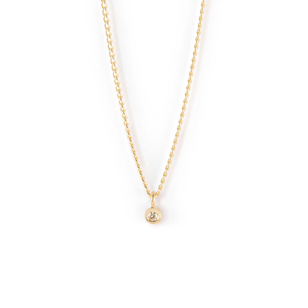 The Axios Diamond Necklace is a special edition solid gold necklace released for Autumn/Winter. Featuring a solitary laba-created diamond in a bezel setting, on a solig gold classic curb style chain. Designed with a vision for sustainability, this necklace is handcrafted with recycled gold and a lab-grown diamond.