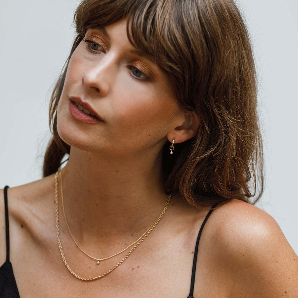 Model wears the Axios diamond set, styled alongside the Dali rope chain necklace in a layered look.