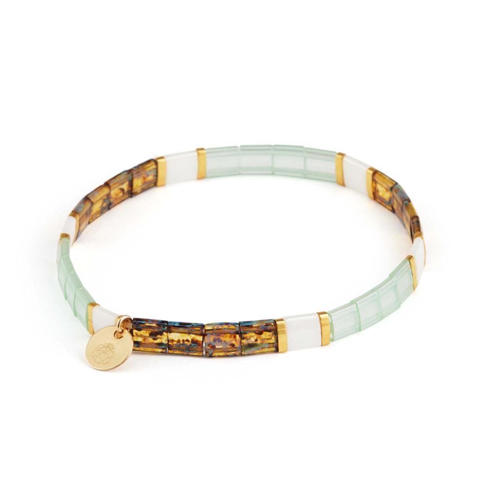 Sea foam green beads are contrasted with white, gold and tortoise Tila beads in this elasticated layering bracelet. Designed and handcrafted in our Devon, UK studio. 
