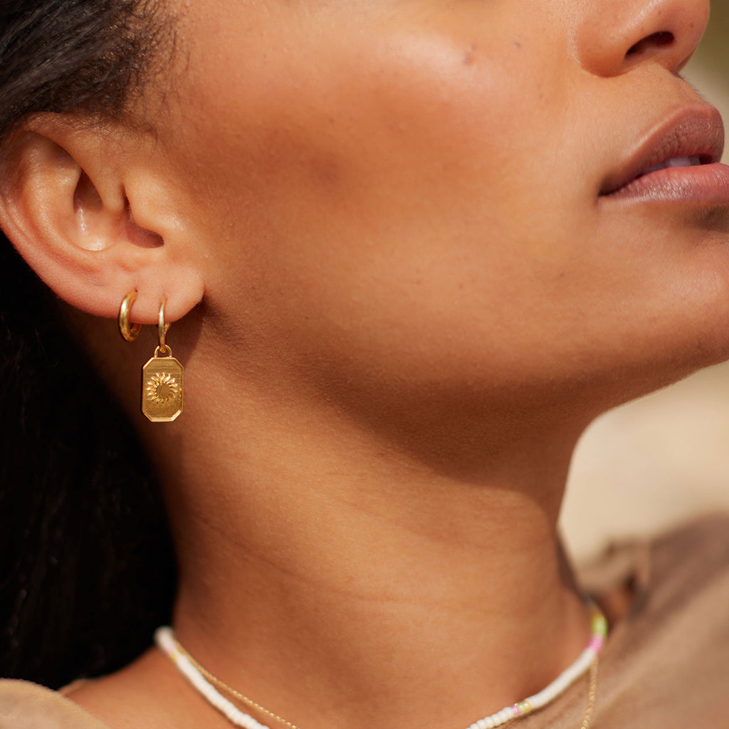 Wanderlust Life Ignis Drop Hoop Earrings. New in the Elemental Collection, gold hoop earrings adorned with a stylised sun. An octagonal hand-cast charm. Proudly designed in Devon, and handcrafted in the UK by our Wanderlust Life global artisan partners.