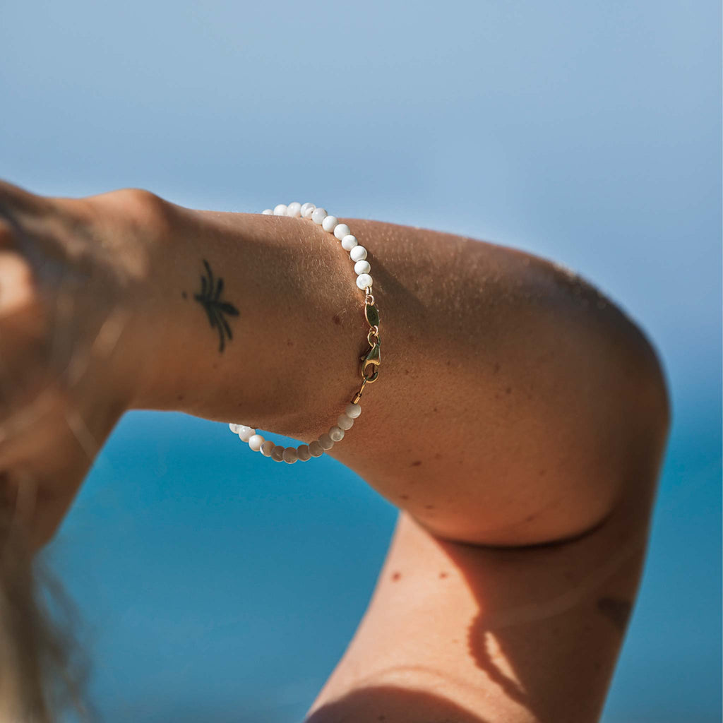 The Kai Beaded Bracelet features Mother of Pearl beaded gemstones all the way around, with a gold vermeil clasp and branded tag.