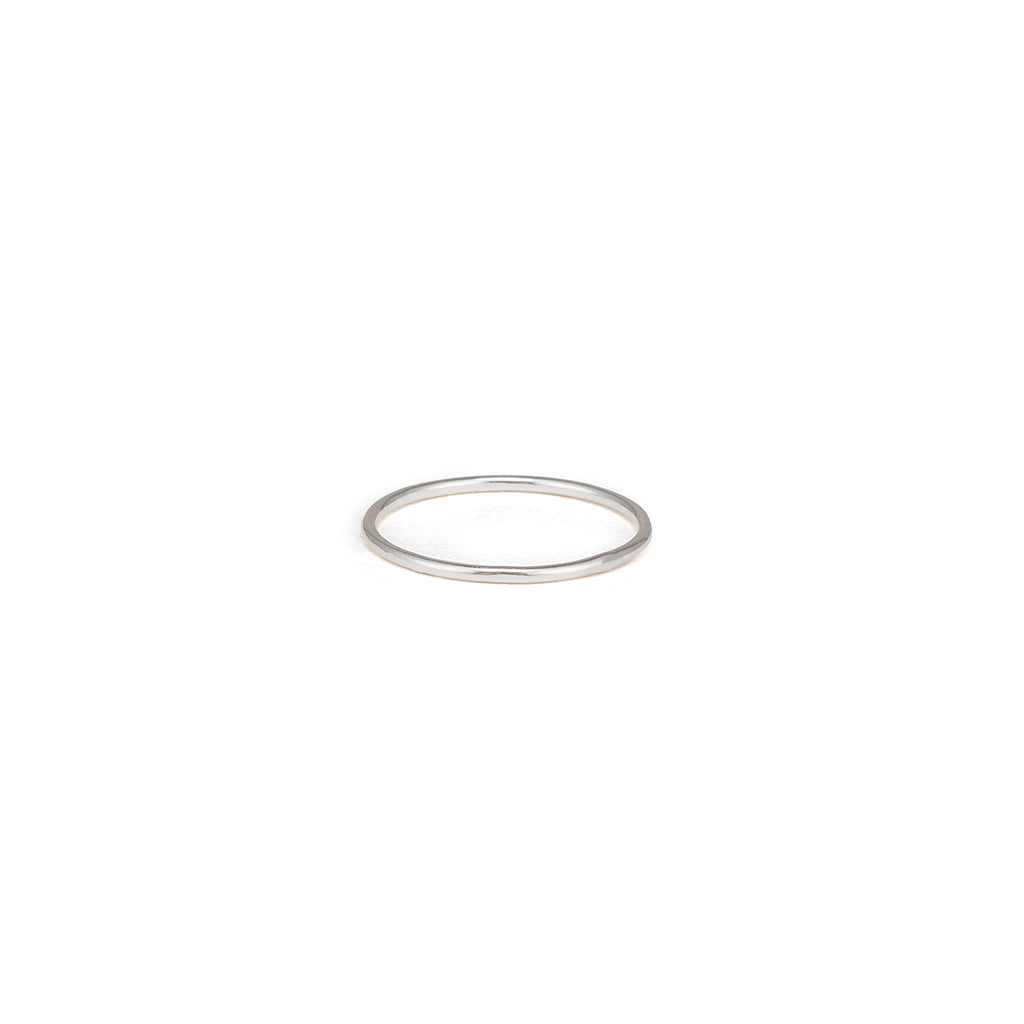 A fine band stacking ring in 925 sterling silver. Hammered in our studio to create a minimally faceted and textured ring, perfect for stacking.