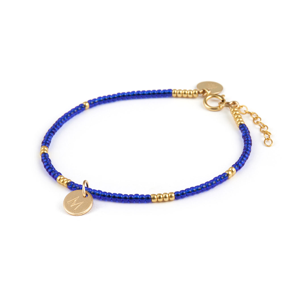 Personalised with a hand-stamped monogram tag, a bright blue beaded bracelet. Shop personalised jewellery online at Wanderlust Life.
