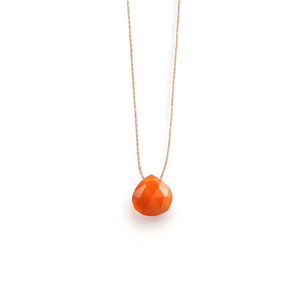 A bright orange carnelian gemstone is strung on a minimal fine cord, forming a minimal gemstone necklace. This sunset orange gem is perfect for summer and dopamine dressing.