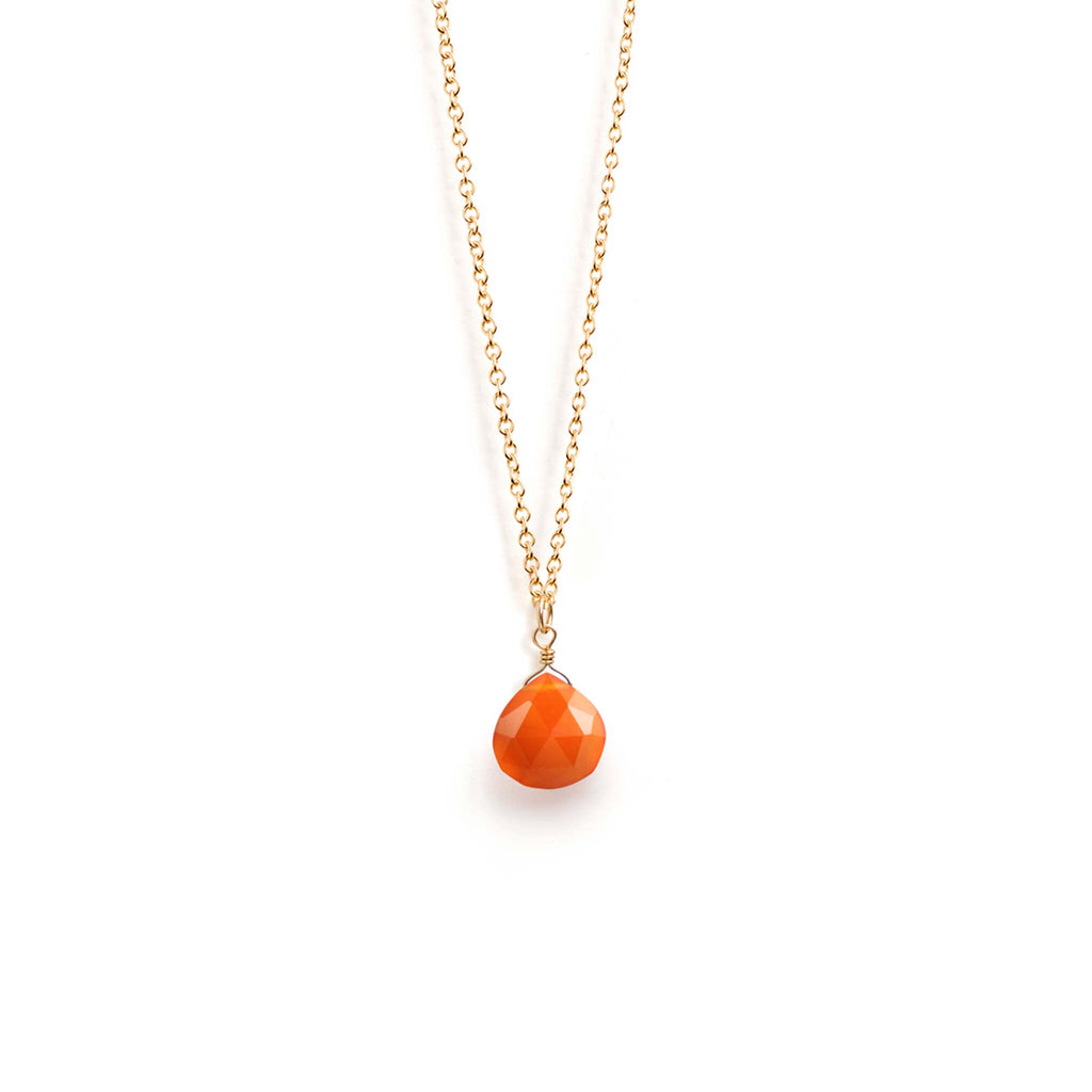 A faceted orange carnelian gemstone hangs from a minimal gold-fill chain. A bright orange gemstone necklace, designed and handcrafted in Devon.