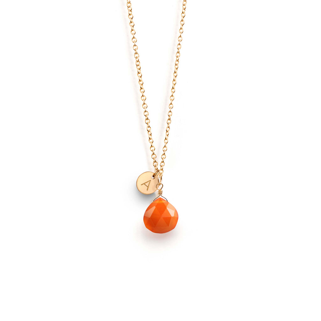 A faceted orange carnelian gemstone hangs from a minimal gold-fill chain, personalised with an A initial charm.