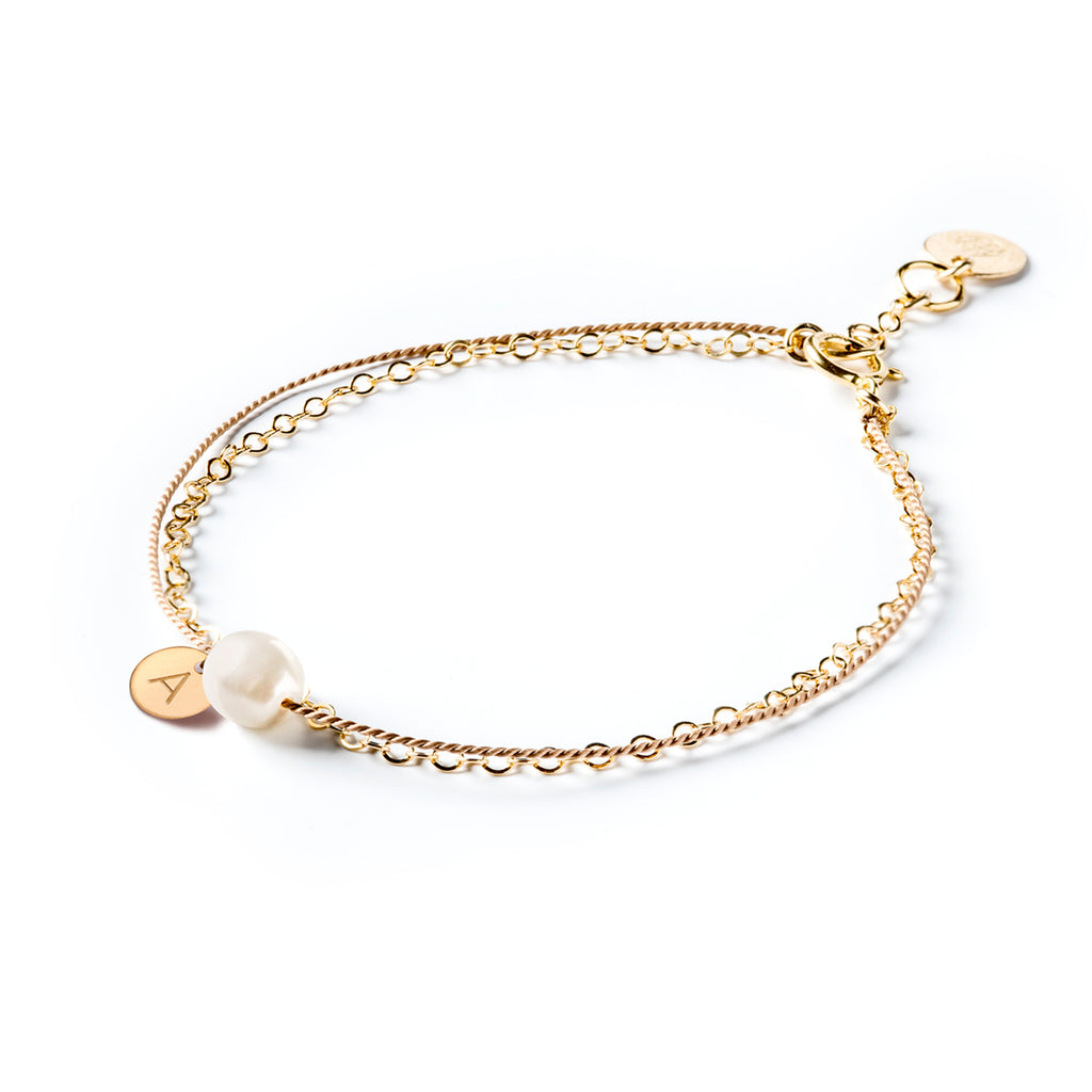 Wanderlust Life personalised gold and silk bracelet with white freshwater pearl. Handmade jewellery in the UK. Shop meaningful jewellery, perfect for gifting online at Wanderlust Life. Personalise your bracelet with a hand-stamped initial tag.