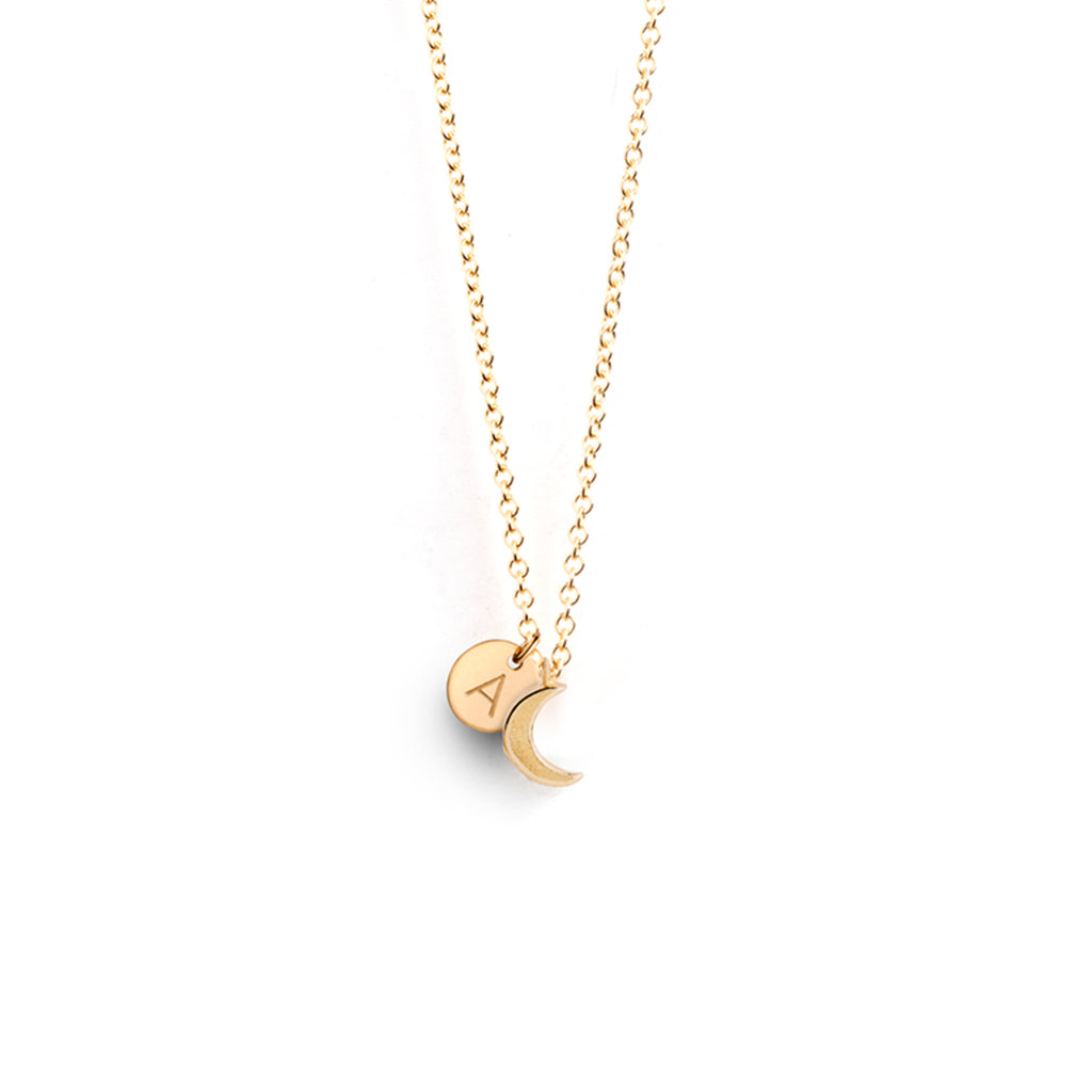 Personalised with an A initial tag, the Petite Luna Necklace features a small crescent moon pendant on an adjustable fine gold chain. Perfect for layering, add a personalised initial necklace to your necklace stack.