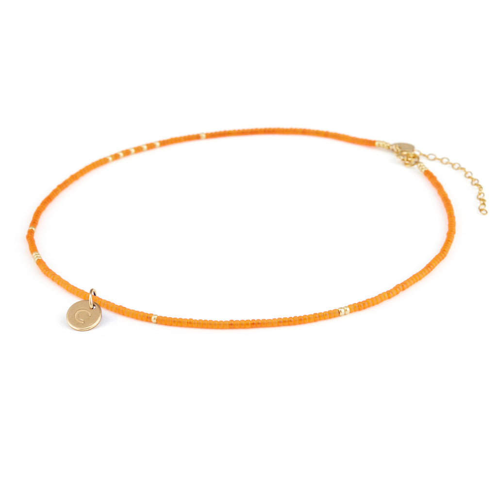 Personalised with a gold fill circular charm, hand-stamped with a C initial, the Orange Tangiers Beaded Necklace is a must-have for adding colour to your wardrobe this summer.