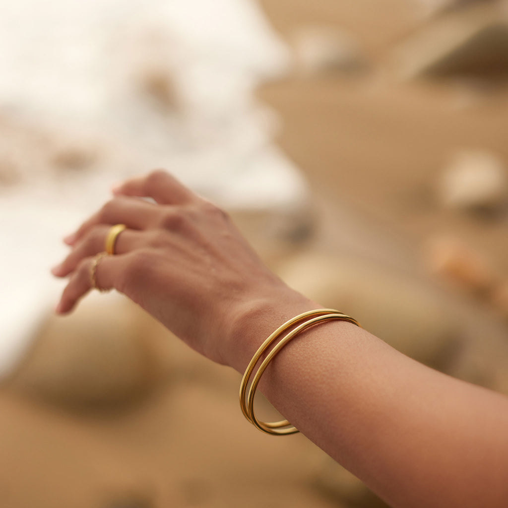 Silke Gold Bangle. 14 carat gold plated hollowed silver bangle. Available in 2 sizes - 64mm or 66mm. Proudly designed in Devon and crafted by our Wanderlust Life global artisan partners