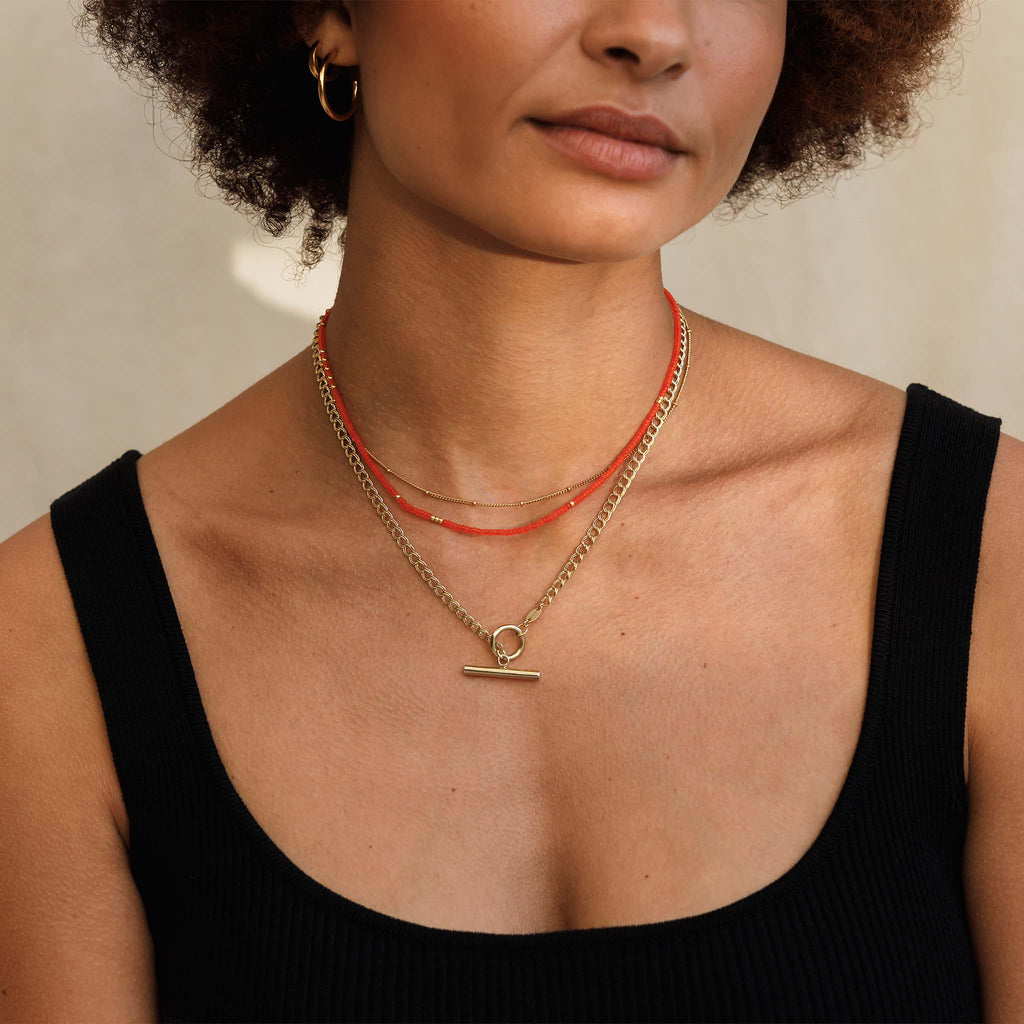 In bright orange beads accented with gold beads, the Tangiers Beaded Necklace is a summer must-have. Styled with gold fill and gold vermeil layering chains.