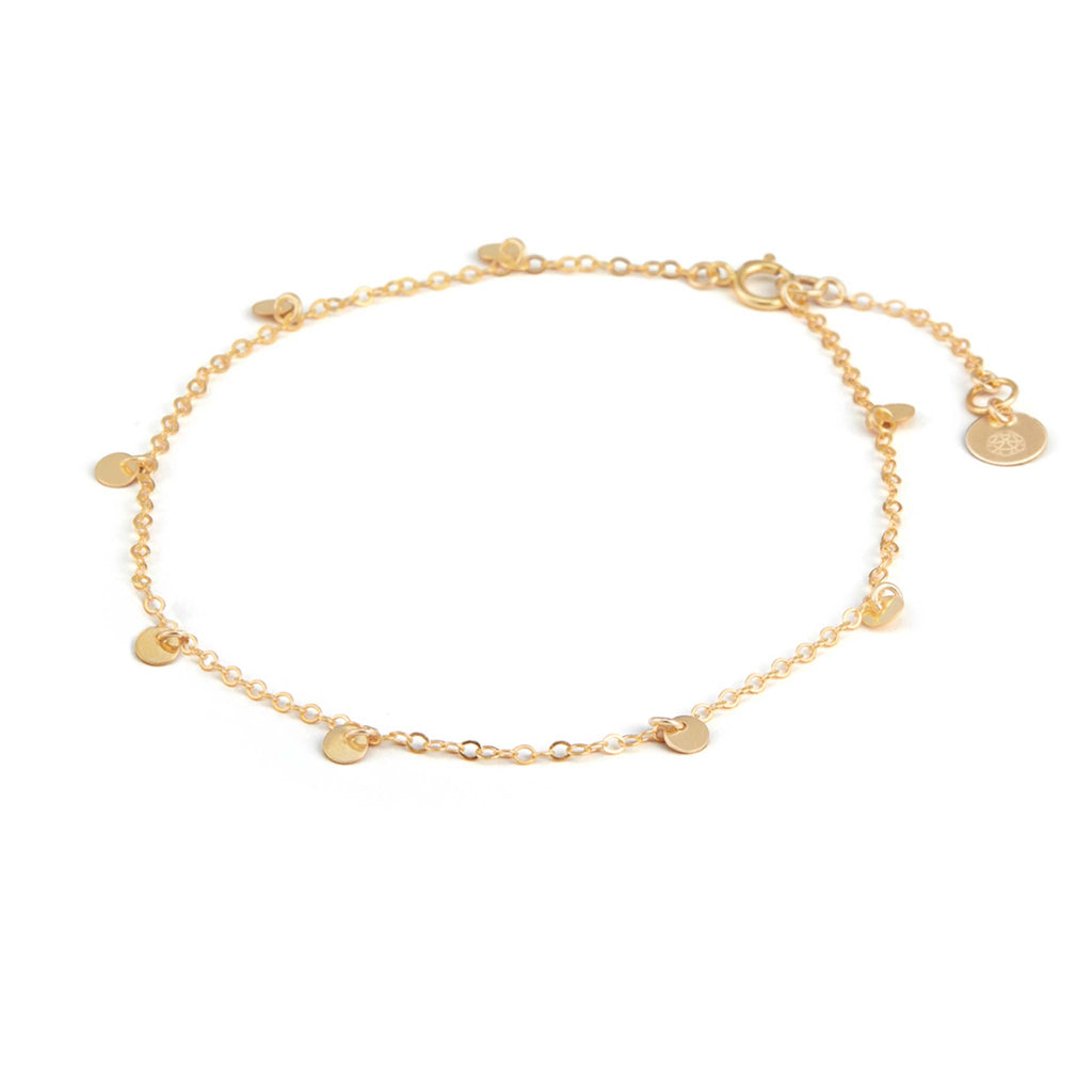 Small gold discs are fastened on a gold-fill chain at regular intervals, forming this charm anklet. Designed and handcrafted in our Devon Studio.