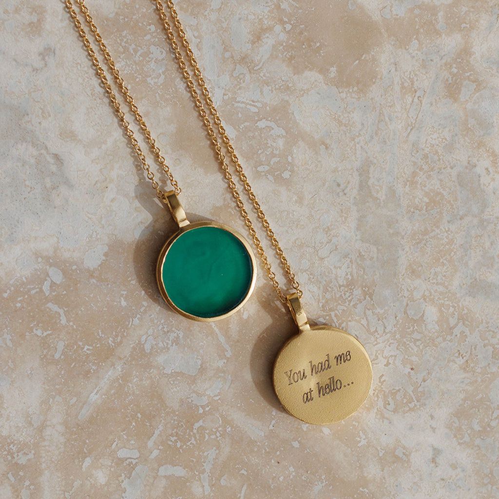 Engraved Green Onyx Porthole Gold Chain Necklace. A circular pendant of gold surrounds a disc of bright green onyx gemstone, hanging from a 19 inch fine gold chain necklace. Proudly designed in Devon & handcrafted by our Wanderlust Life global artisan partners.