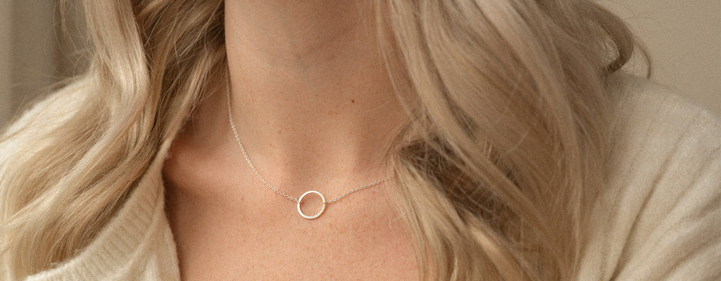 Silver circle pendant on a silver chain necklace. Handmade by Wanderlust Life.