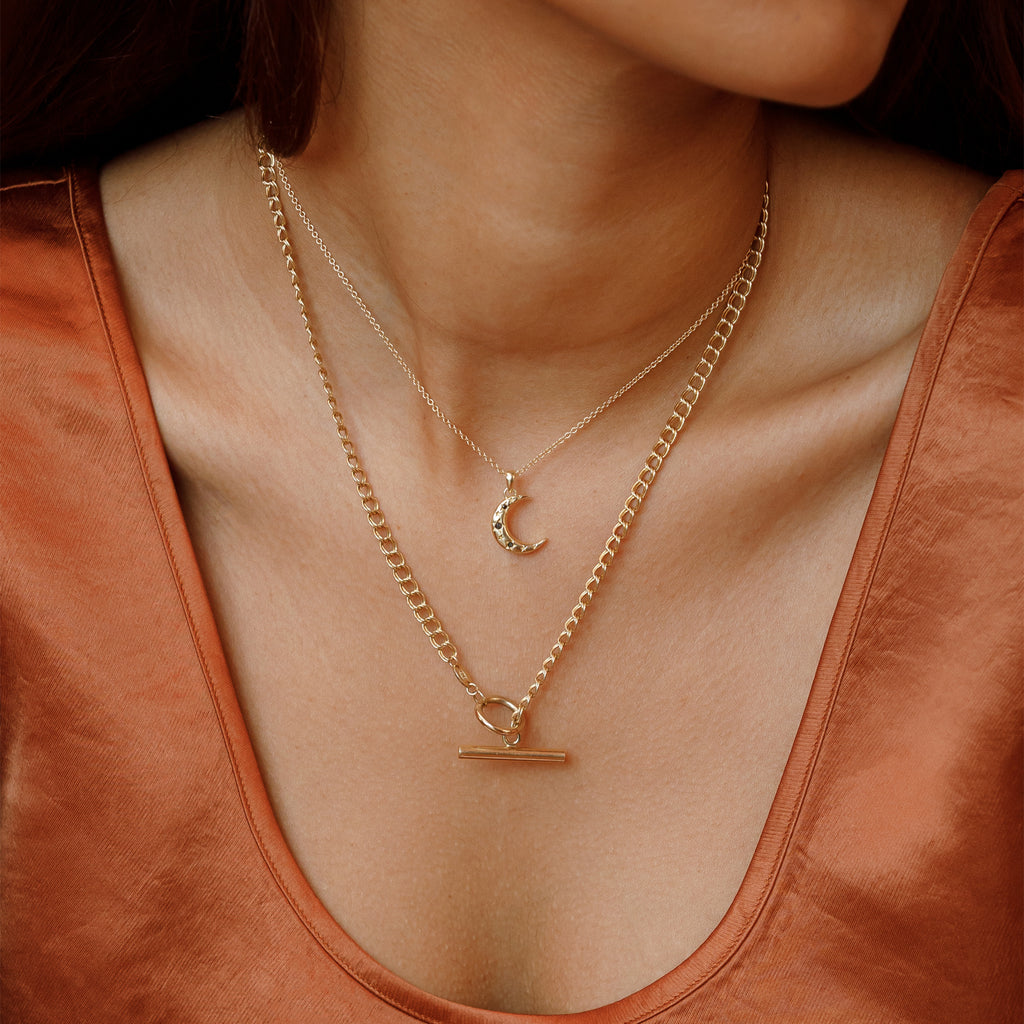 Model wearing the Black Diamond Lunara Crescent Pendant Necklace with the Morgan Double Curb Toggle Necklace.