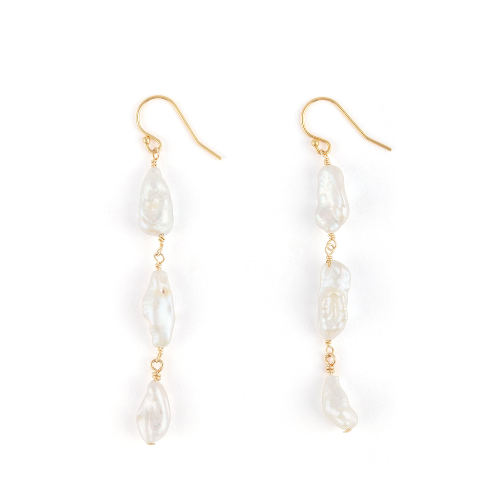 A trio of luminous freshwater pearls hand on a 14k gold fill earwire.