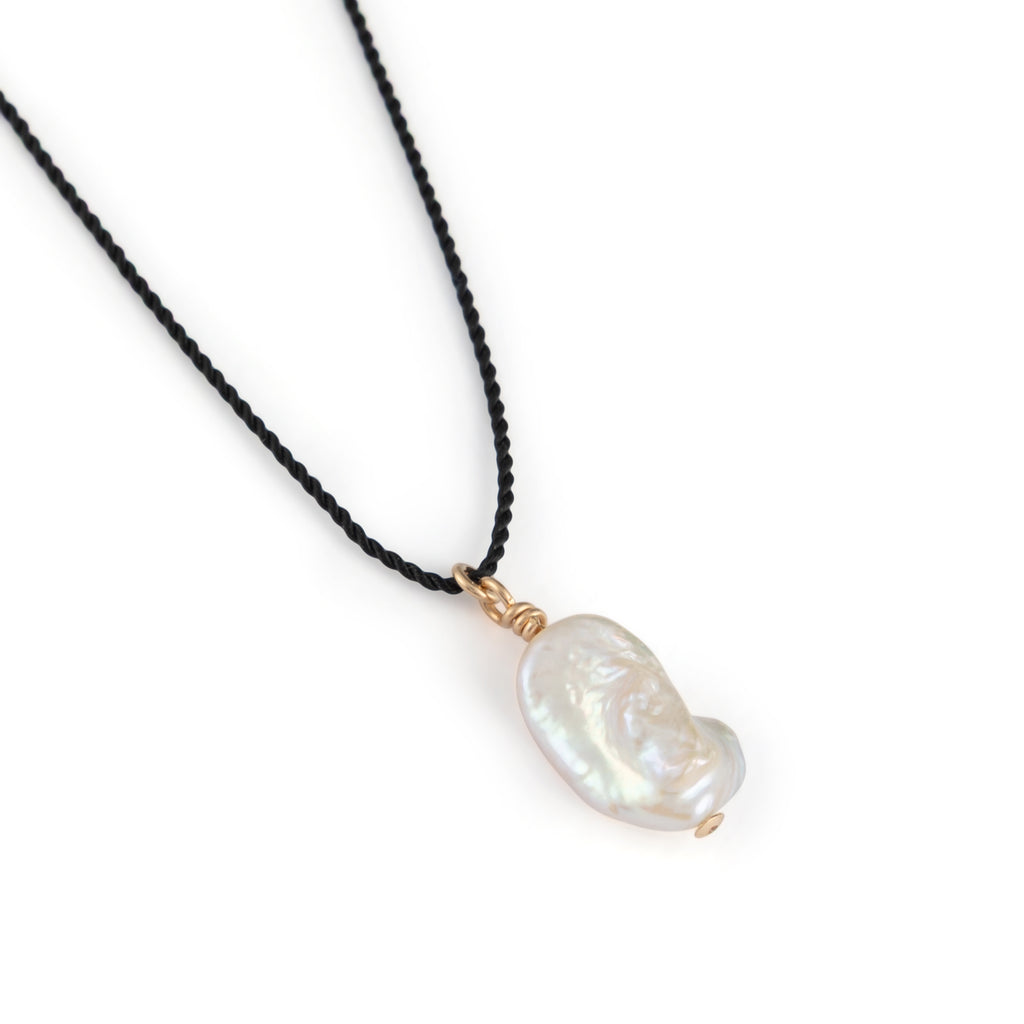 A single freshwater “Kiwa” shaped pearl strung on a black silk cord - a striking twist on our signature fine cord necklaces. 
