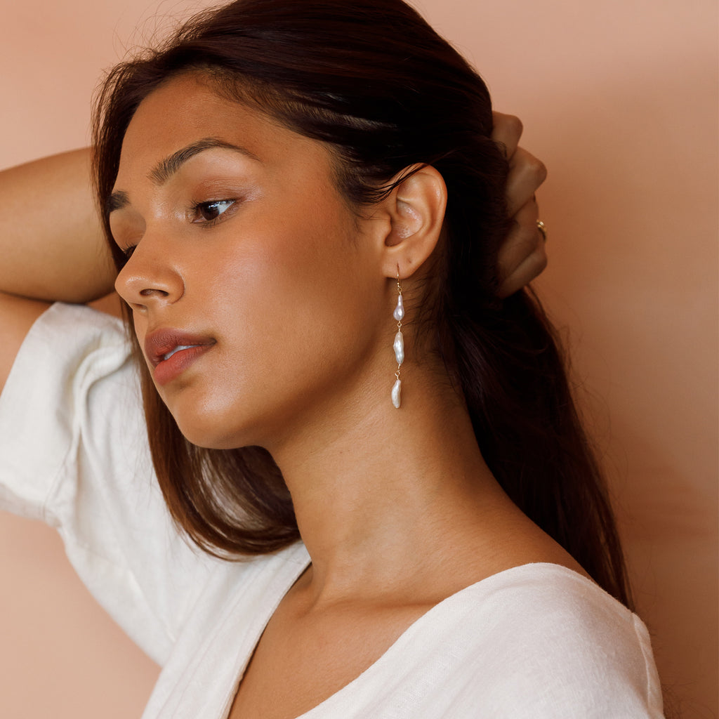 A trio of luminous freshwater pearls hand on a 14k gold fill earwire.