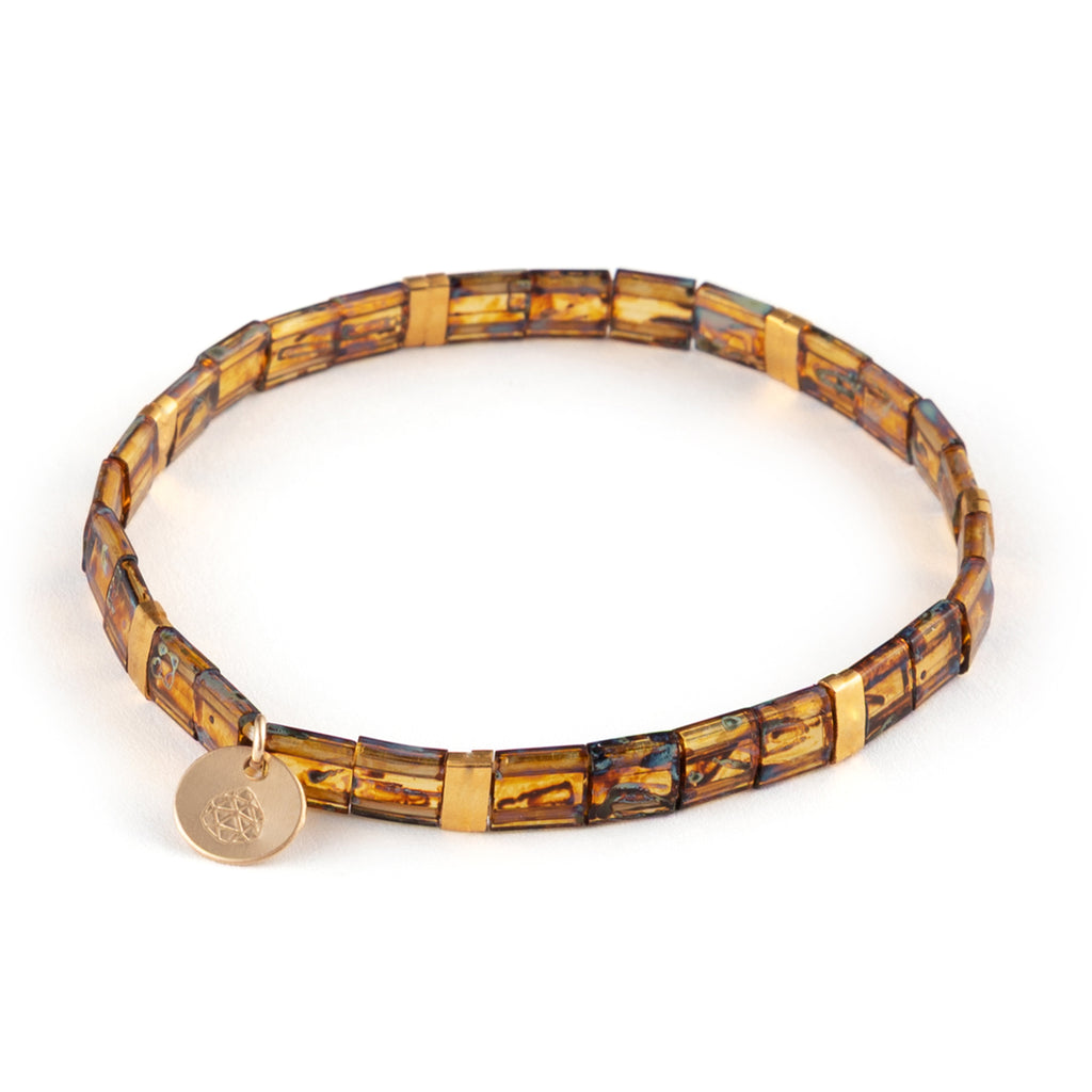 Glossy glass beads in warm amber shades, flecked with aqua streaks that mimic Pāua shell, strung on elastic for effortless layering.