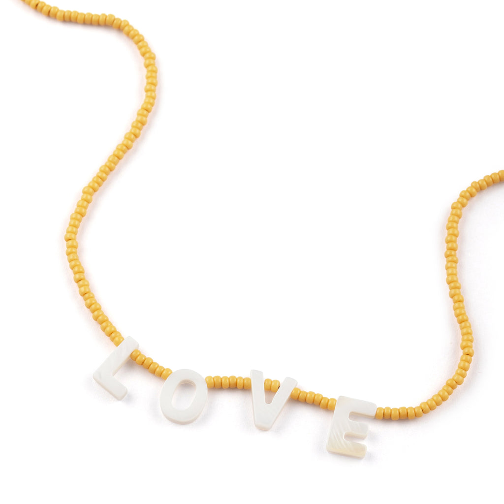 Featuring seed beads in sun-soaked lemon, our beaded necklace showcases mother-of-pearl letters that spell out L-O-V-E. 