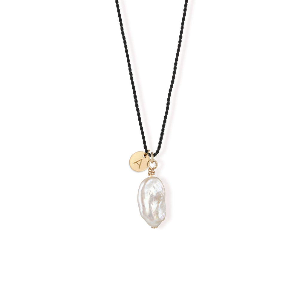 A single freshwater “Kiwa” shaped pearl strung on a black silk cord - a striking twist on our signature fine cord necklaces.  Personalised with a 14k gold fill hand stamped initial tag.