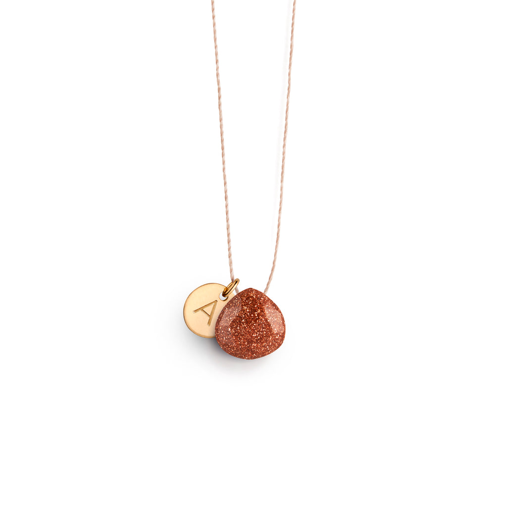  A radiant copper-flecked goldstone sparkles like a miniature glitterball strung on a minimal fine cord necklace. Personalised with a 14k gold fill initial tag.