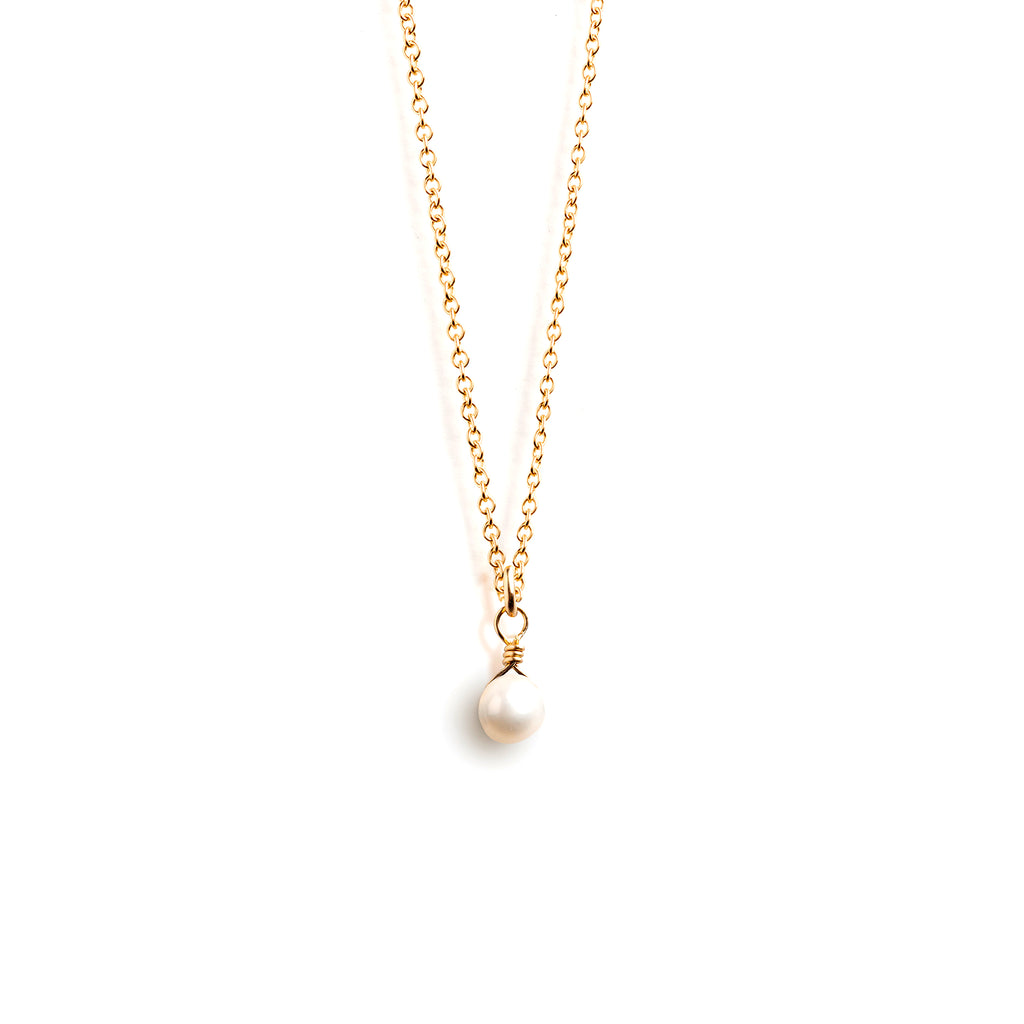 Wanderlust Life Petite Pearl Pendant Necklace. A minimal pearl drop hangs from a choker style 14k gold fill chain. Perfect for layering with Wanderlust Life necklaces. Proudly designed and handcrafted in our studio in Devon, UK.
