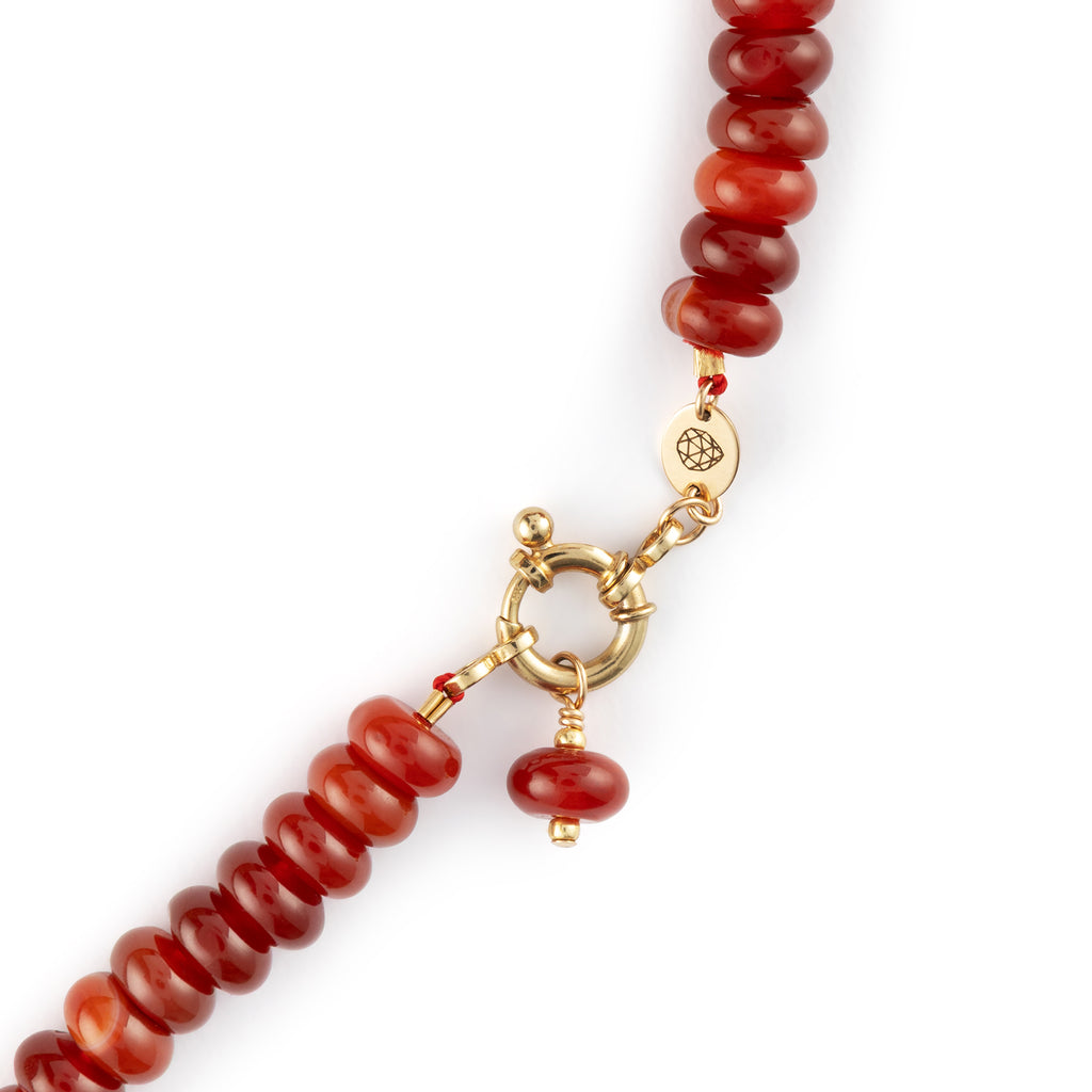  Chunky Red Agate gemstones on a doughnut beaded necklace with a golden ring fastening like a ship’s wheel, designed to sit front and centre. 