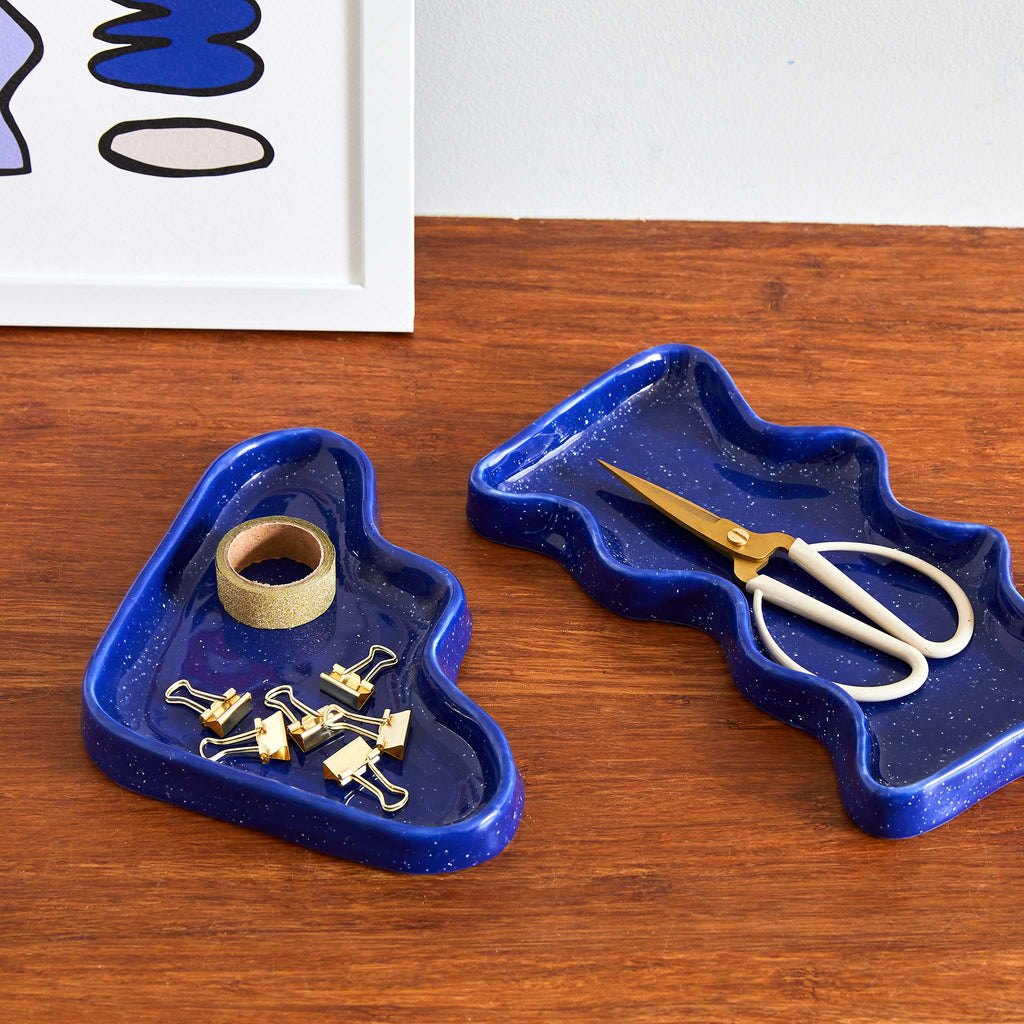 A ceramic triangular tray in a deep blue, speckled effect glazing.