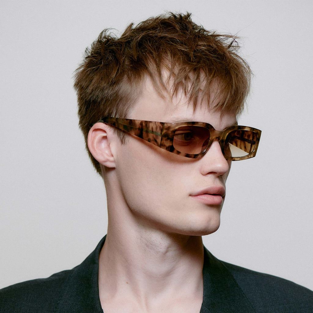 These sunglasses feature a mottled pattern in neutral colours across the frame, with yellow, light toned frames. They’re soft and edgy with angled and linear frames to combine a casual feel with more statement sunglasses.