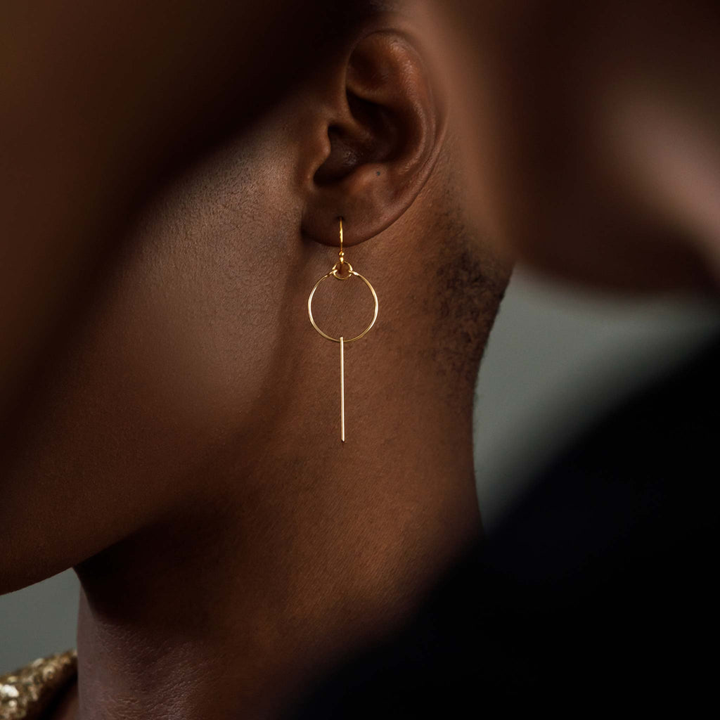 To represent energy and light, linear drop earrings combine a circular shape and a fine gold bar. Handcrafted with 14k gold fill for a lasting gold finish.