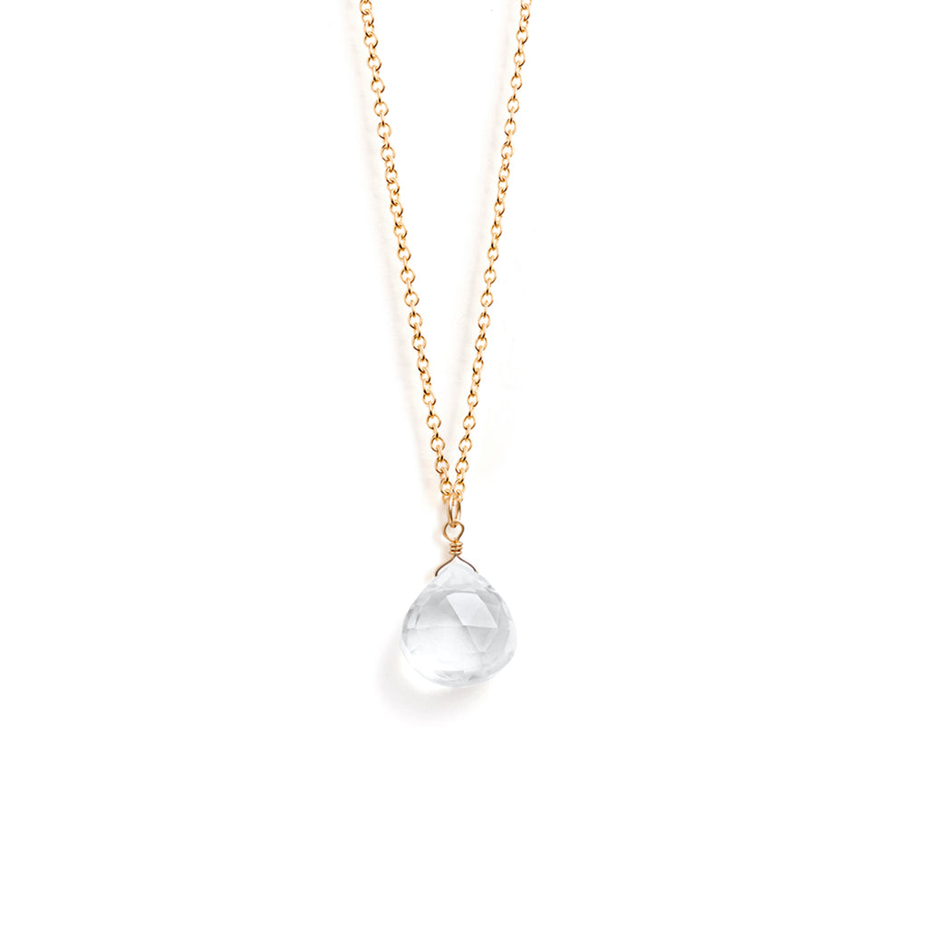 A clear quartz gemstone in our signature faceted shape floats on a minimal gold chain necklace. Meaningful birthstone jewellery designed and handcrafted in Devon.