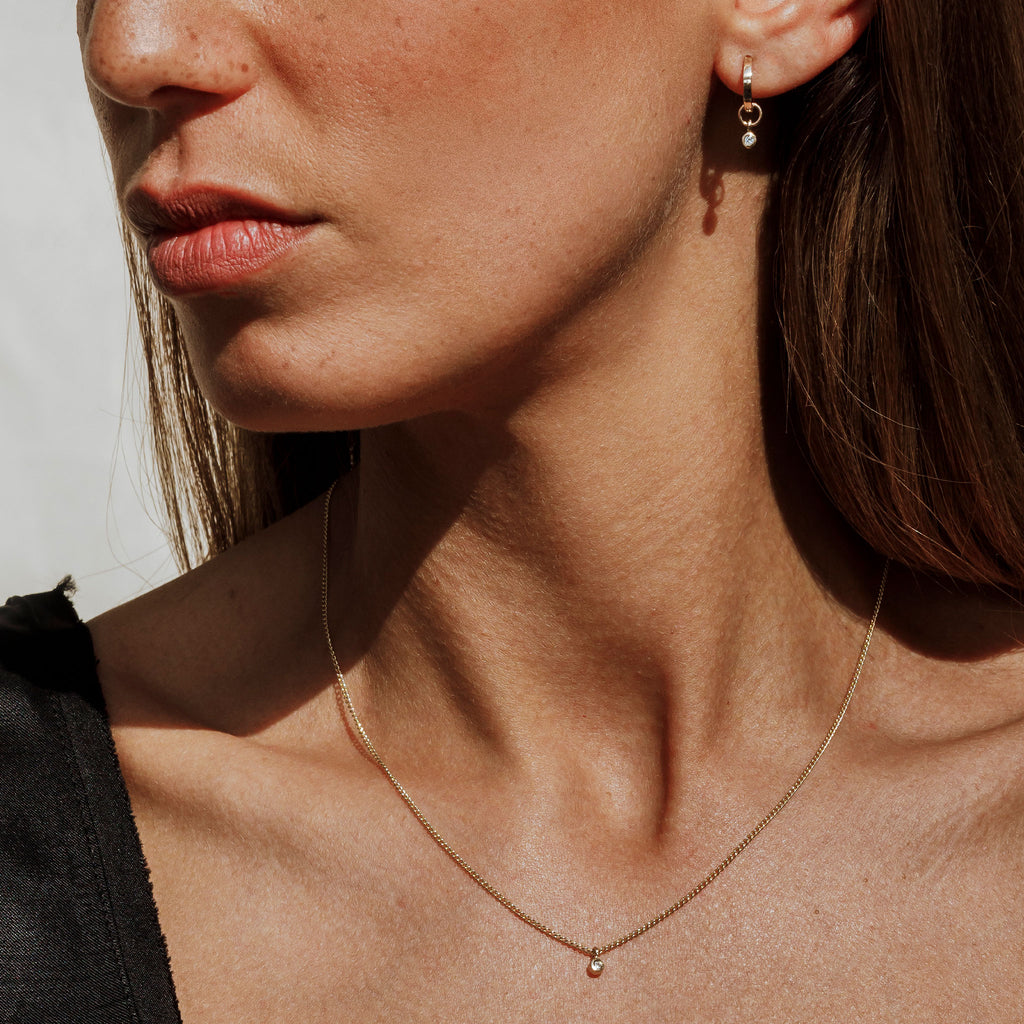 Wearing the Axios Diamond Necklace and Earrings as a matching set. Featuring 9k solid gold and lab created diamonds. This limited edition necklace adds an effortless spark to any outfit, and makes the perfect meaningful gift.