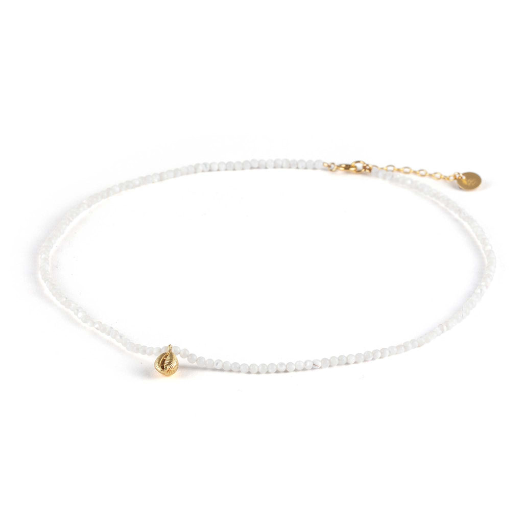 A dainty hand-cast cowry shell dances on a mother of pearl beaded choker necklace. Designed in Devon and handcrafted with a 14k gold vermeil shell pendant and 14k gold fill adjustable chain.