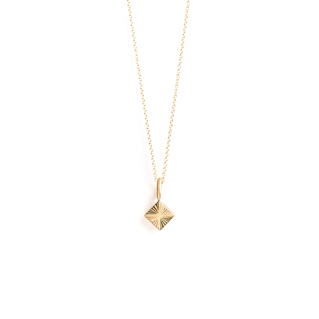 The Castillo Necklace features a diamond shape pendant with etched lines, symbolic of rays of light. On a minimal, adjustable chain perfect for layering. Handcrafted with 14k gold fill and gold vermeil.