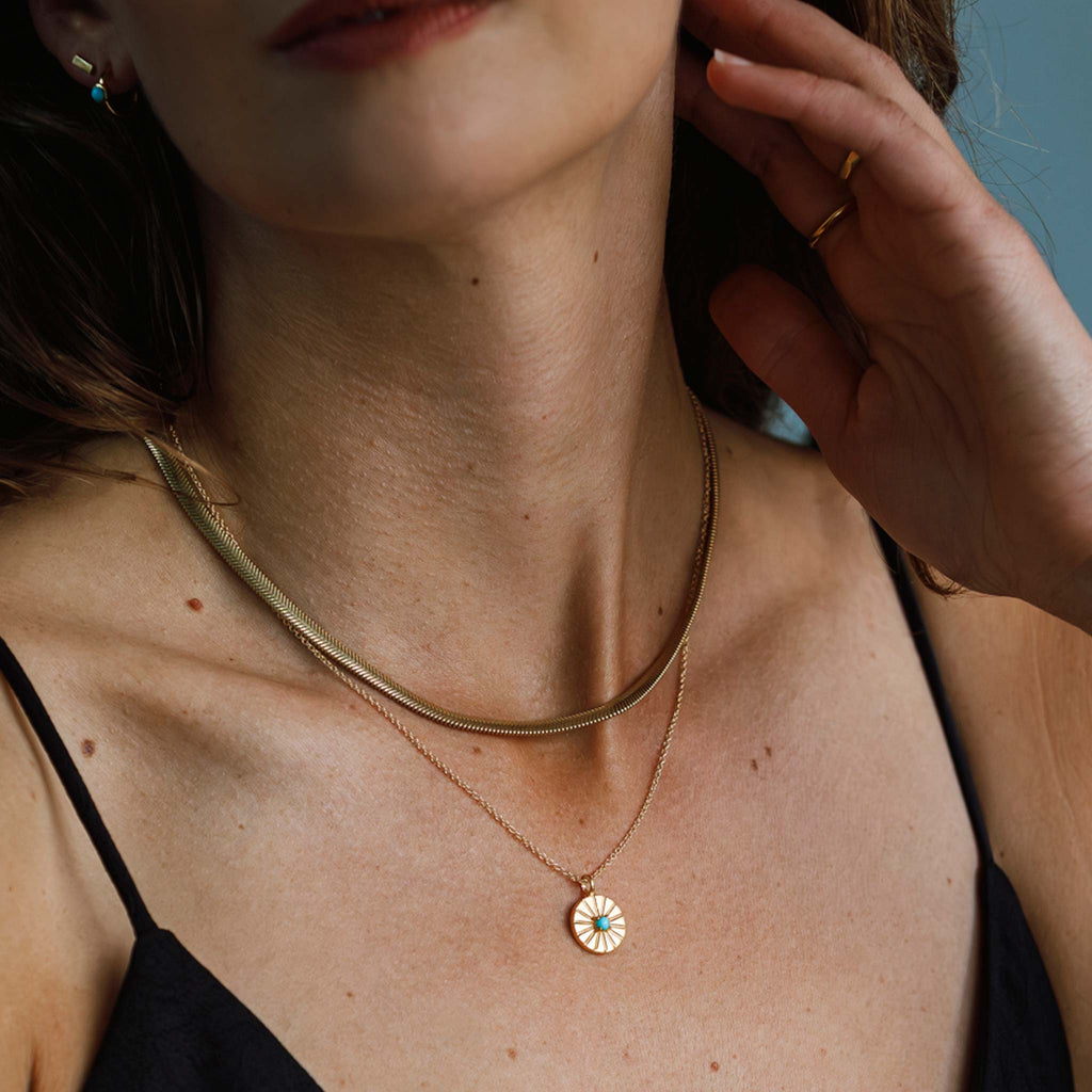 The Paseo Herringbone chain is a signature statement snake chain necklace, ideal for wearing solo or layering. Styled with the December Turquoise Mini Sundial Birthstone Necklace.
