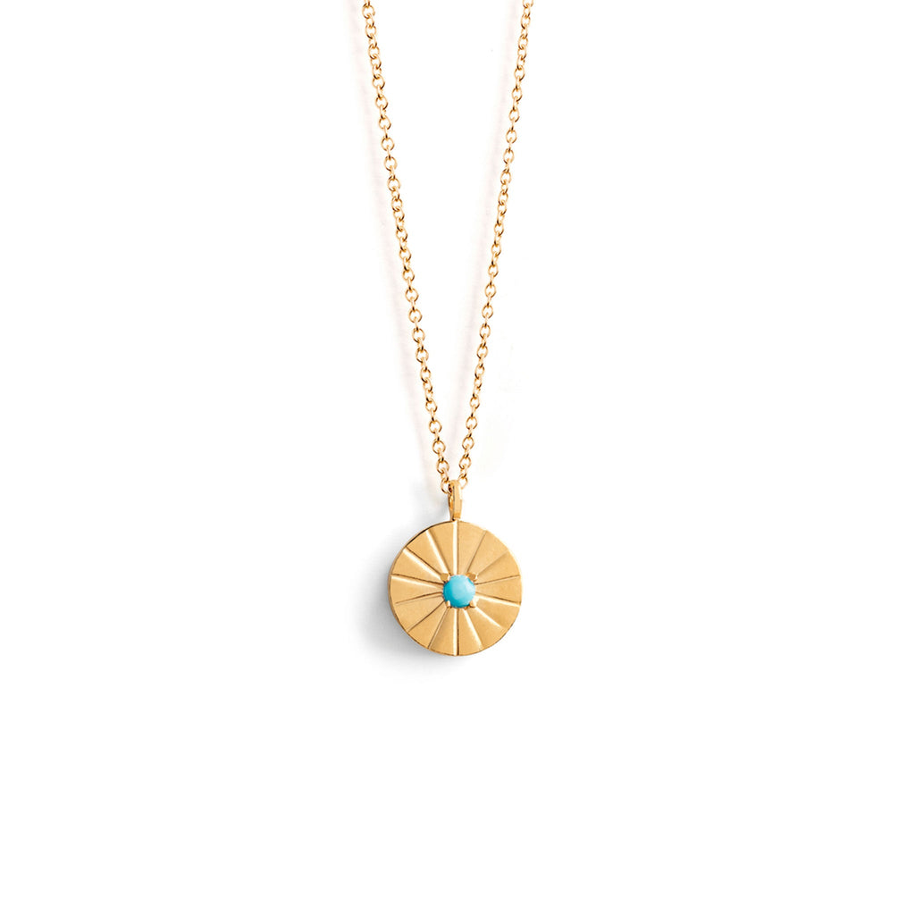 Wanderlust Life December Birthstone Necklace. Etched beams radiate from a turquoise gemstone. On a minimal, gold adjustable chain; wear this necklace between 16 and 18 inches. The perfect piece for necklace layering and gifting. Personalise the pendant with free engraving. Designed in Devon and handcrafted by our Wanderlust Life Global Artisan Partners.