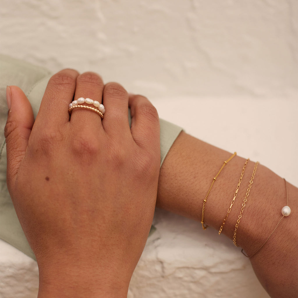 Wanderlust Life Deep Dive Pearl Ring. White freshwater pearls are strung on elastic to form this beaded style ring. This statement occasion ring is perfect for summer 2023's pearl trend. Stack with our bestselling gold stacking rings to curate your own personal ring stack.