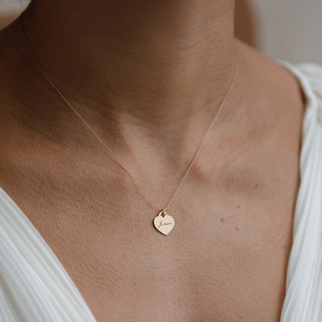 Model wears the minimal yet meaningful Love Note Heart Fine Cord Necklace. Engraved with the phrase 'Je t'aime', this heart necklace is a new favourite symbol of love. Customise your necklace with free engraving.