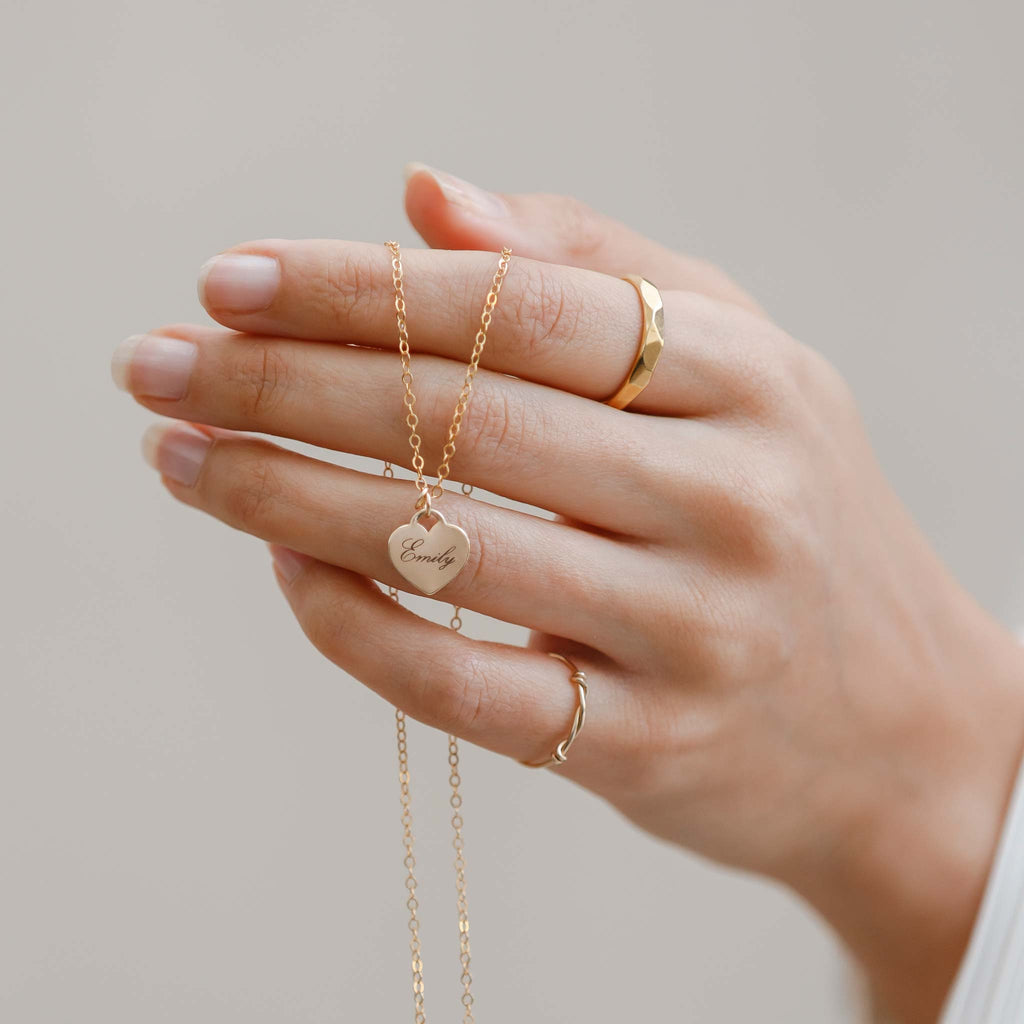 The Love Notes Heart pendant necklace is engraved with the name Emily in Antique Script, an italic and cursive font. Shop personalised jewellery with free engraving.