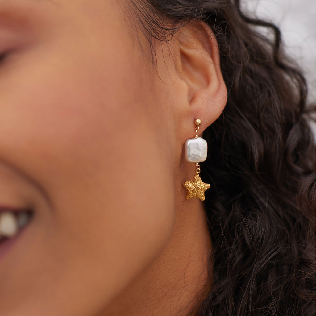 Wanderlust Life Eventide Drop Earrings. Square pearls and gold starfish are suspended from minimal gold stud earrings. New in the Sea Dreams collection, these statement studs are a must-have jewellery accessory this summer. Discover the Sea Dreams collection online at Wanderlust Life.