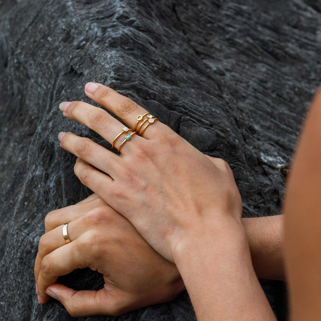 The Opal Mano Ring styled in a colourful ring stack with turquoise, peridot, moonstone rings.