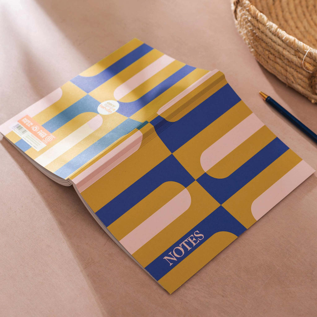 An A5 notebook featuring a chartreuse and navy blue geometric design.