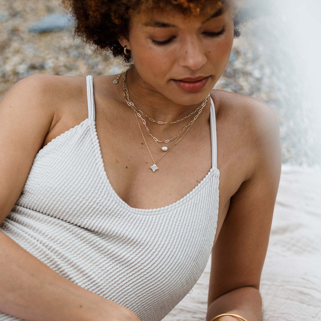 A four-pointed star of brushed gold surrounds a slice of iridescent mother of pearl.