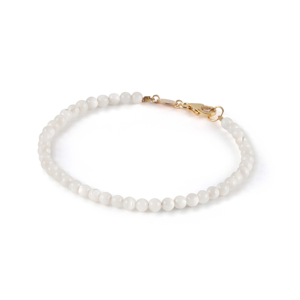 Mother of Pearl bead gemstones are string on silk to form a minimal and pearly gemstone bracelet. Designed and handcrafted in our Devon studio. Shop gemstone jewellery online at Wanderlust Life.